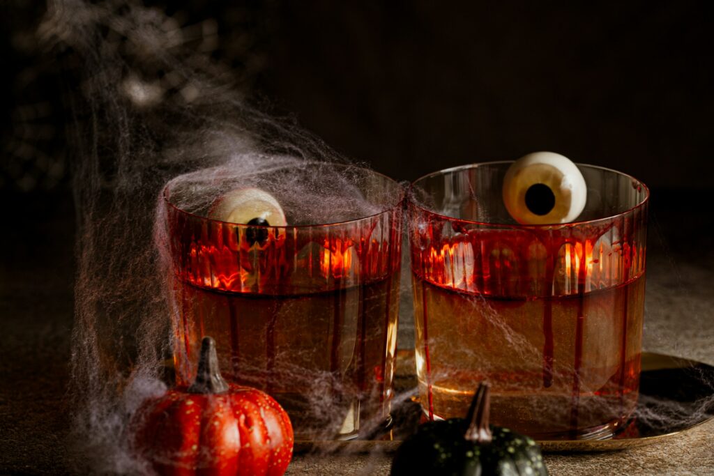 spooky delicious halloween cocktails with fake eyeballs and cobwebs