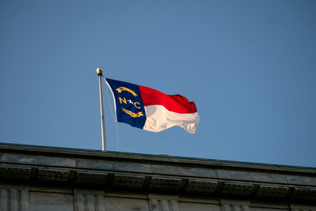 a photo of a north carolina flag waving on a rooftop in raleigh