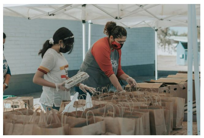 two people volunteering and filling paper bags