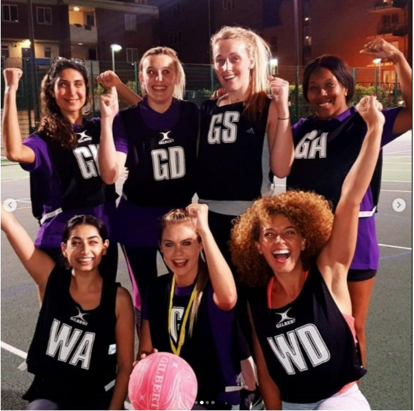 7 women gathered together cheering for a sports team