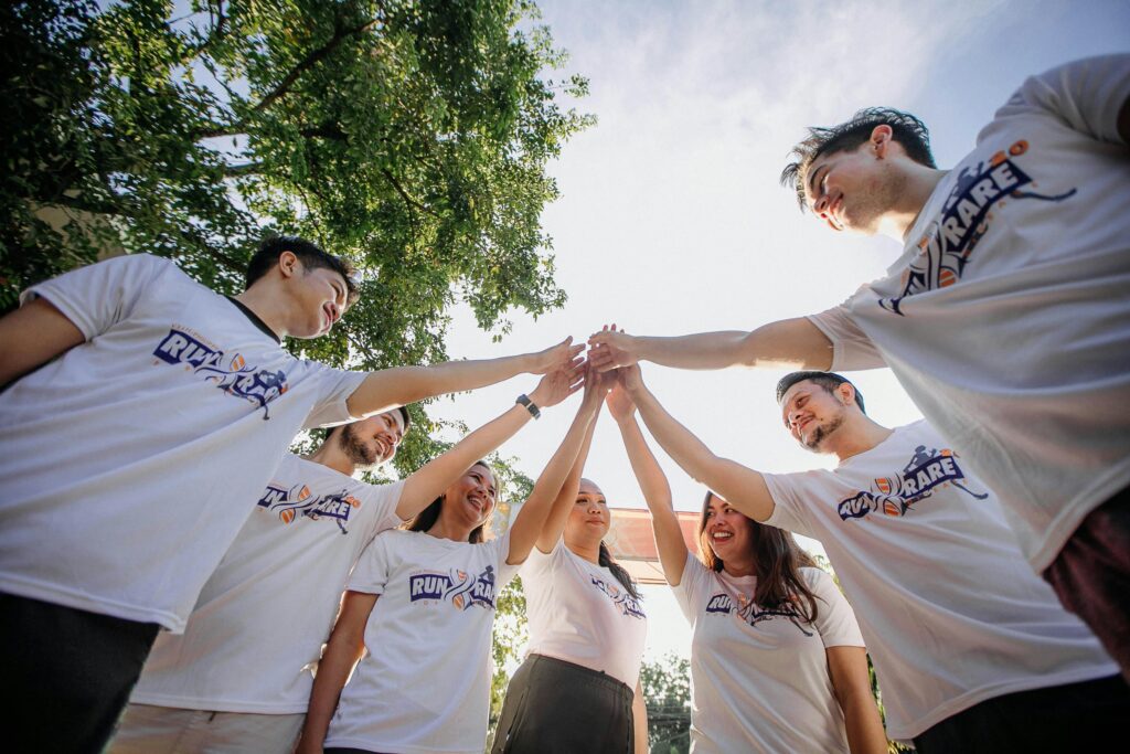 group of people outside with hands joined together in middle