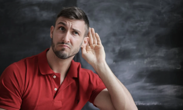 person holding up their hand to listen