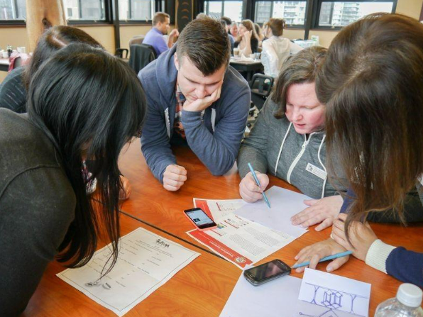 people gathered around a table looking at paper